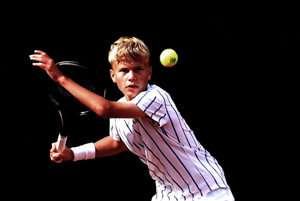 joueur de tennis ultra concentré sur la balle juste avant de la frapper avec sa raquette